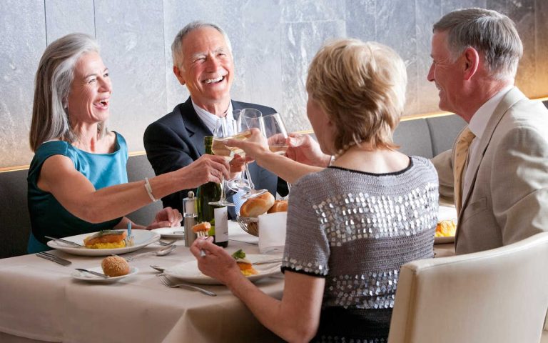 Four older people sitting at a dining table.