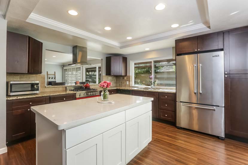 Dual paned windows make for plentiful natural light and new plantation shutters for privacy and a touch of sophistication. The open floor plan downstairs features a large kitchen with formal dining area and clear lines of site to the living room with a wall of windows and slider to the backyard, and a den with a cozy fireplace and yard access. 