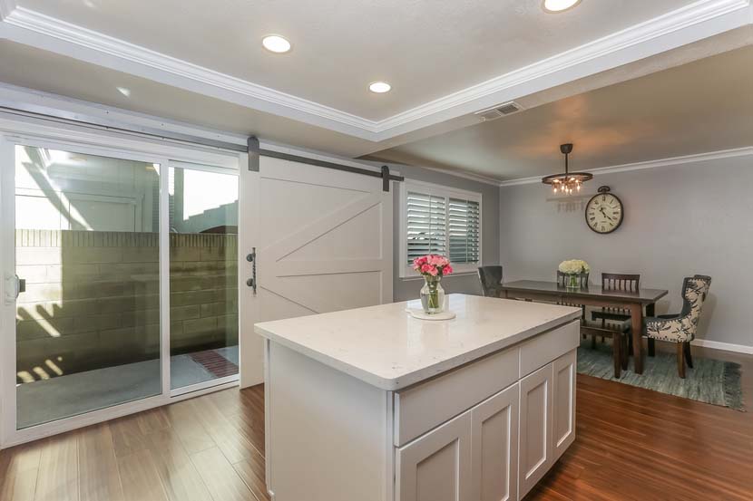 Dual paned windows make for plentiful natural light and new plantation shutters for privacy and a touch of sophistication. The open floor plan downstairs features a large kitchen with formal dining area and clear lines of site to the living room with a wall of windows and slider to the backyard, and a den with a cozy fireplace and yard access. 