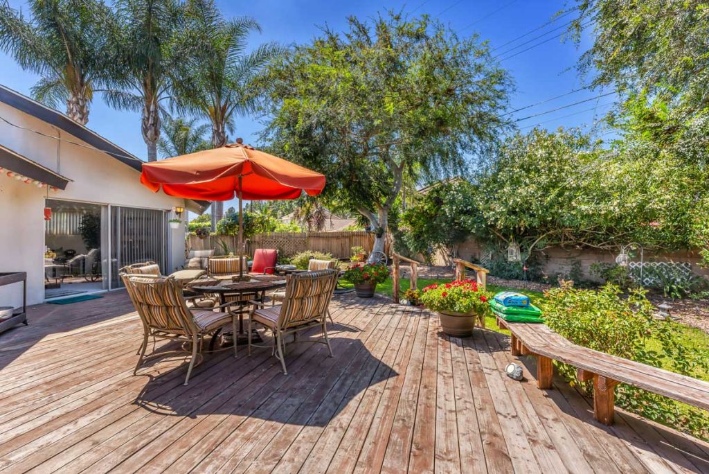 backyard deck with table and red umbrella