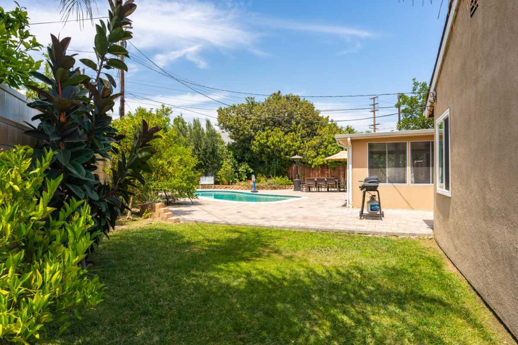 grassy space in backyard with pool in background