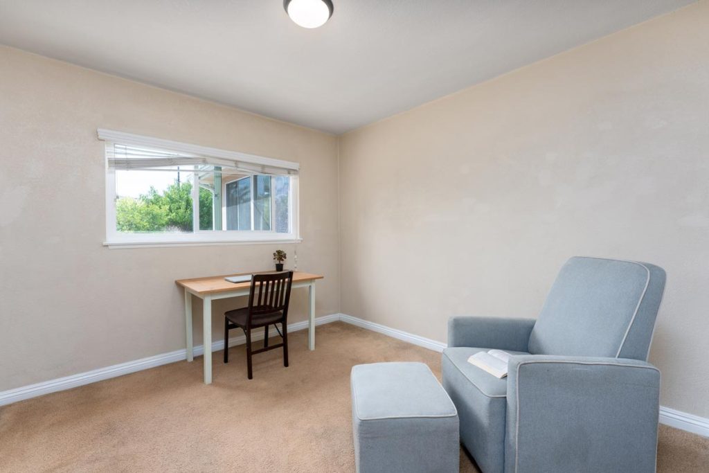 bedroom with chair and desk with a window above