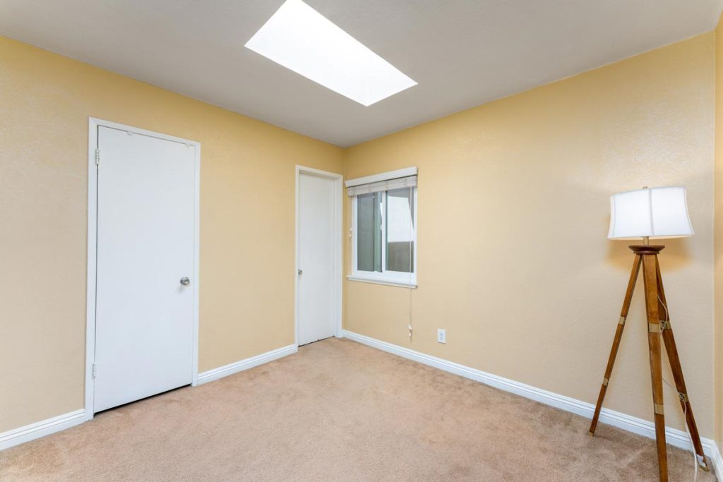 bedroom with floor lamp and small window