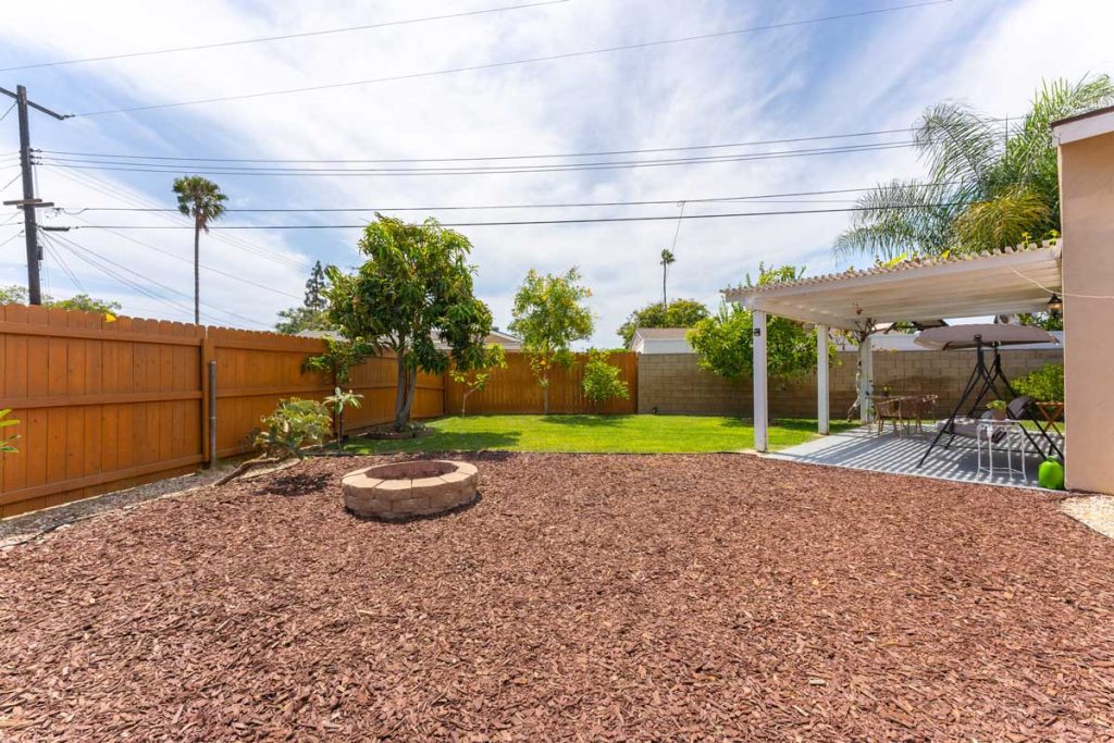 large yard with mulch and fire pit