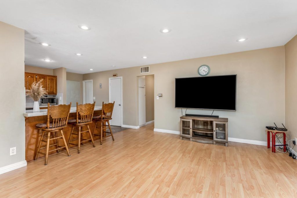 view of kitchen bar with seating and tv mounted on wall