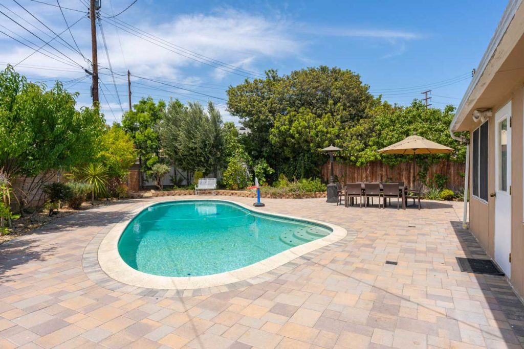 view of pool and dining table in a backyard