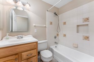 tub/shower combo, toilet and sink with mirror