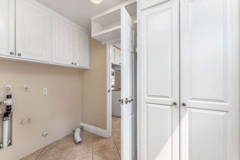 empty laundry room with cabinets and open door