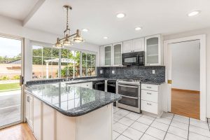kitchen with white cabinets and black granite