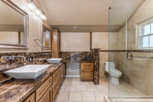 master bathroom with two sinks, toilet and shower
