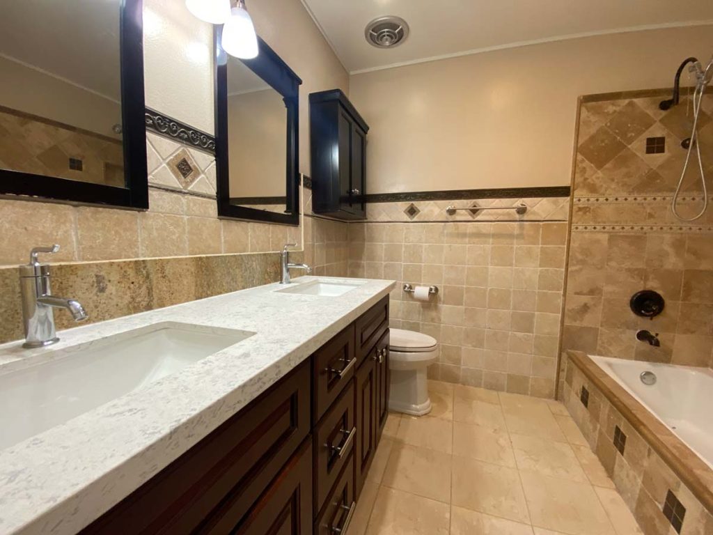 bathroom with quartz counters, toilet and tub/shower combo