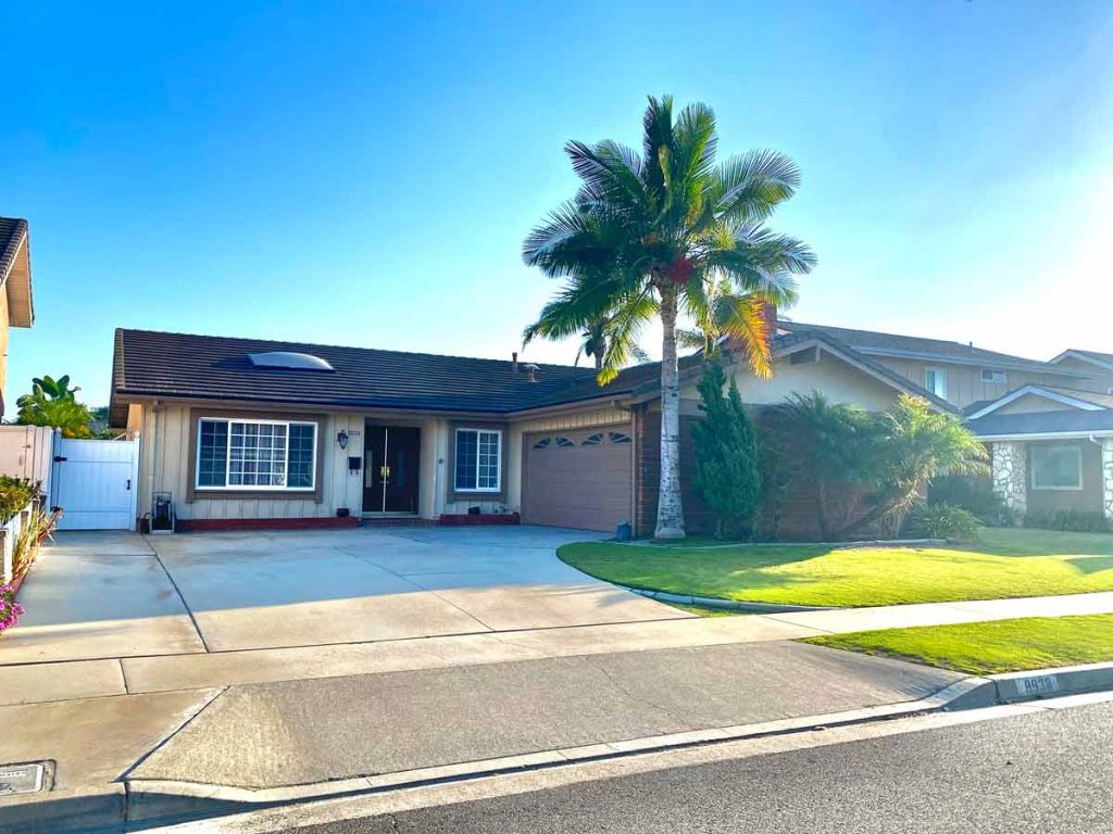 front of house with garage and palm tree