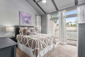 bedroom with large windows and vaulted ceilings