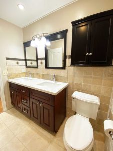 bathroom with double vanity and toilet
