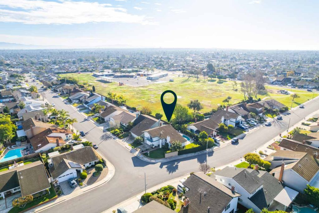 aerial view of neighborhood with arrow pointing to house for sale