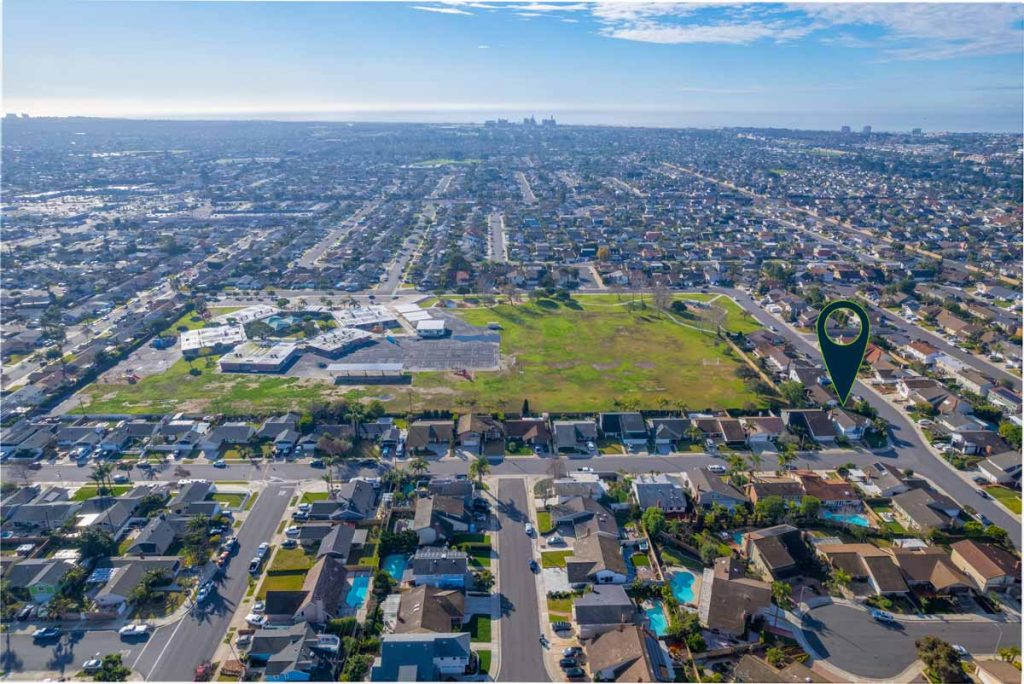 aerial view of neighborhood with arrow pointing to house for sale