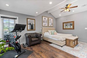 master bedroom with bed, chair and exercise bike
