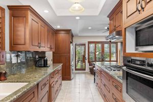 galley style kitchen with granite and darker wood cabinets