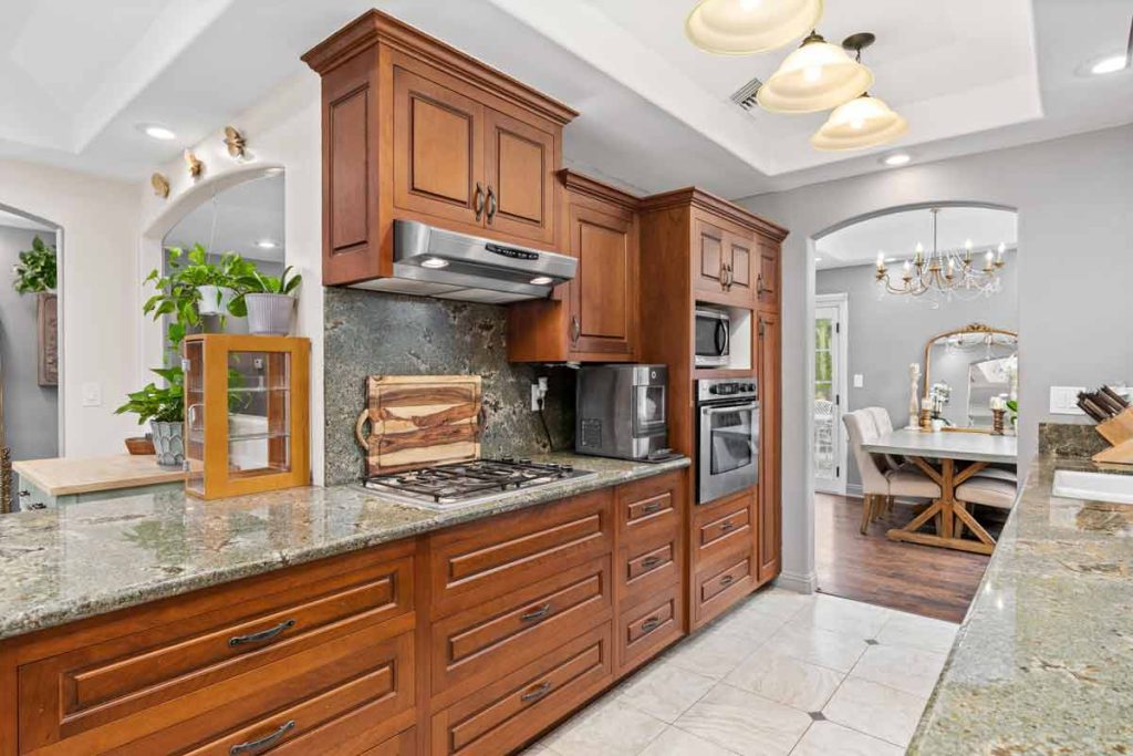 galley style kitchen with granite and darker wood cabinets