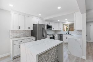 upgraded white kitchen with island and marble counters