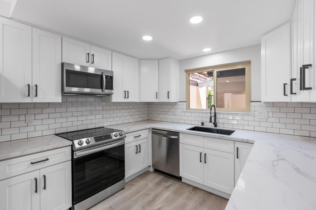 upgraded white kitchen with marble counters