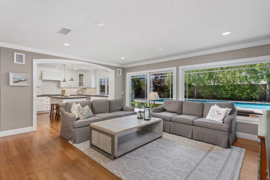 living room with couch and large windows overlooking the pool