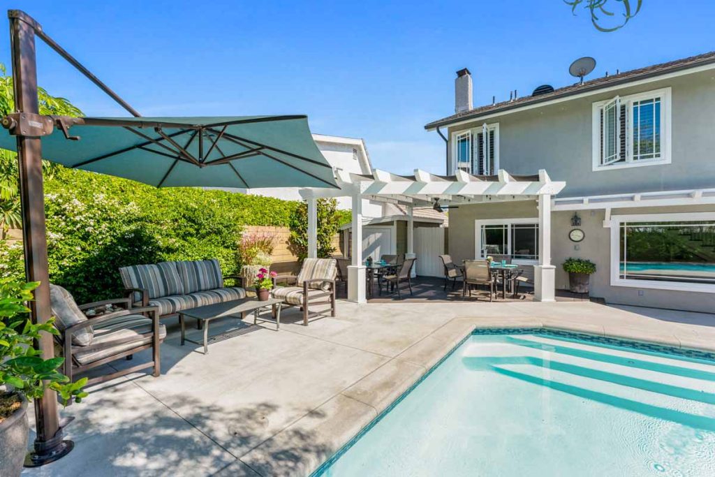 backyard pool with umbrella and pergola