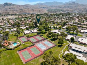 aerial view of rancho mirage community with tennis courts and mountains in background