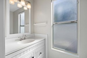 bathroom with white vanity and window