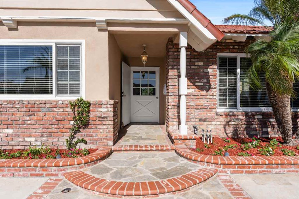 front exterior entryway with red brick accents and a white dutch door