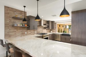 updated kitchen with stone counters and overhead lighting
