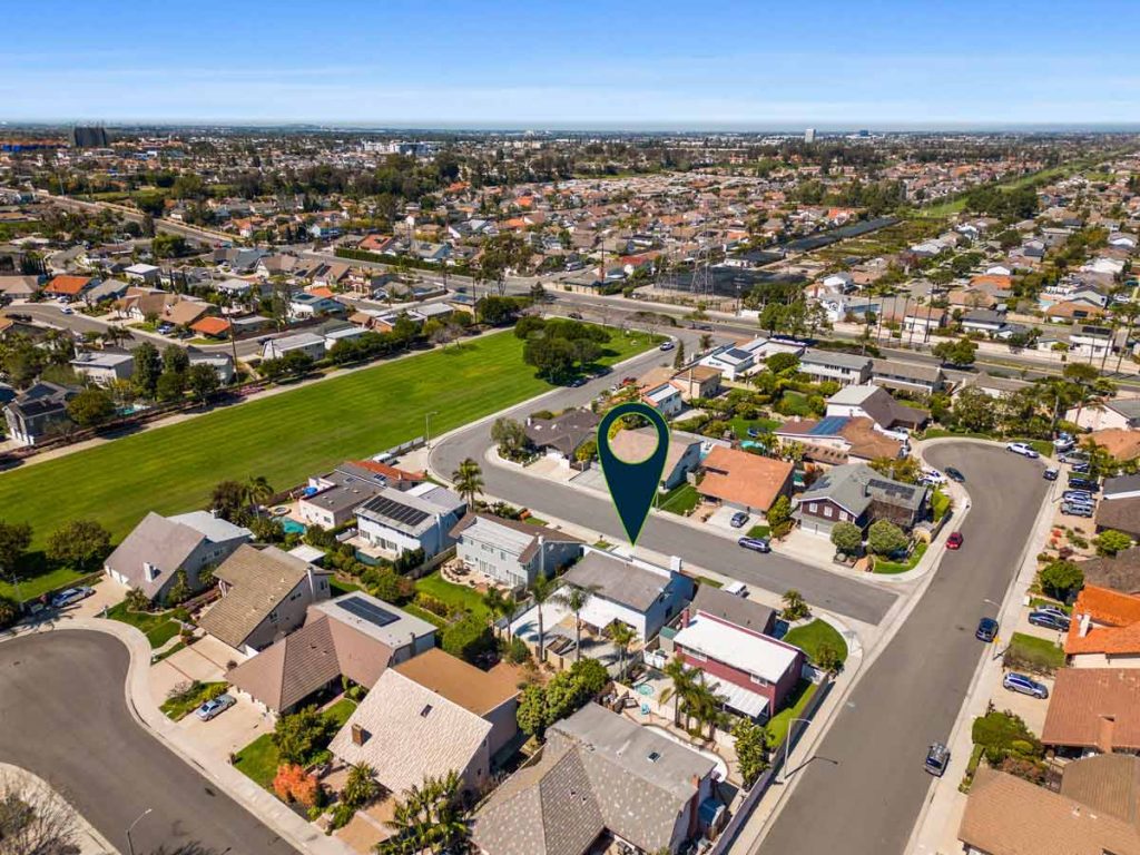 aerial view of neighborhood with large greenbelt and arrow pointing to house for sale