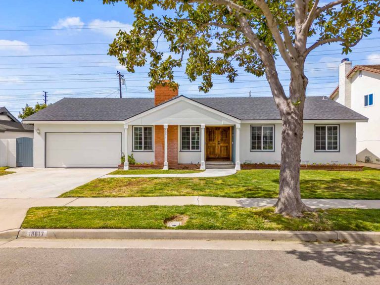 front view of home with white siding, gray roof, and brick accents
