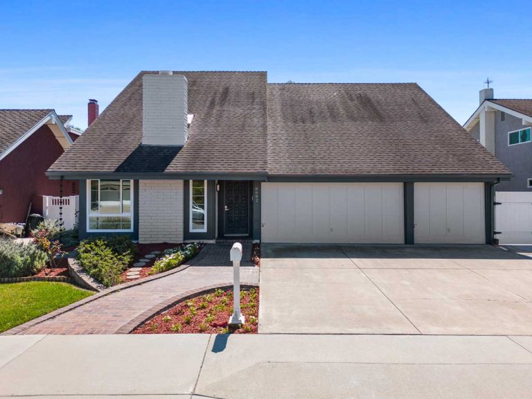 front of home with three car garge and steeply sloped roof