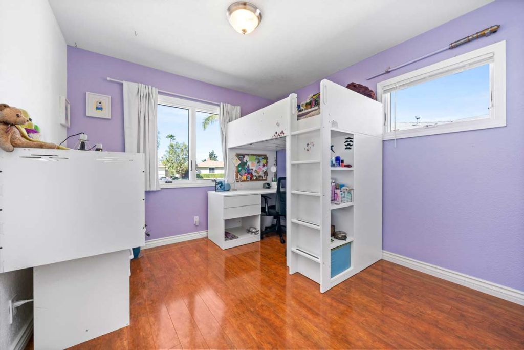 violet colored walls in child's bedroom with white loft bed and desk