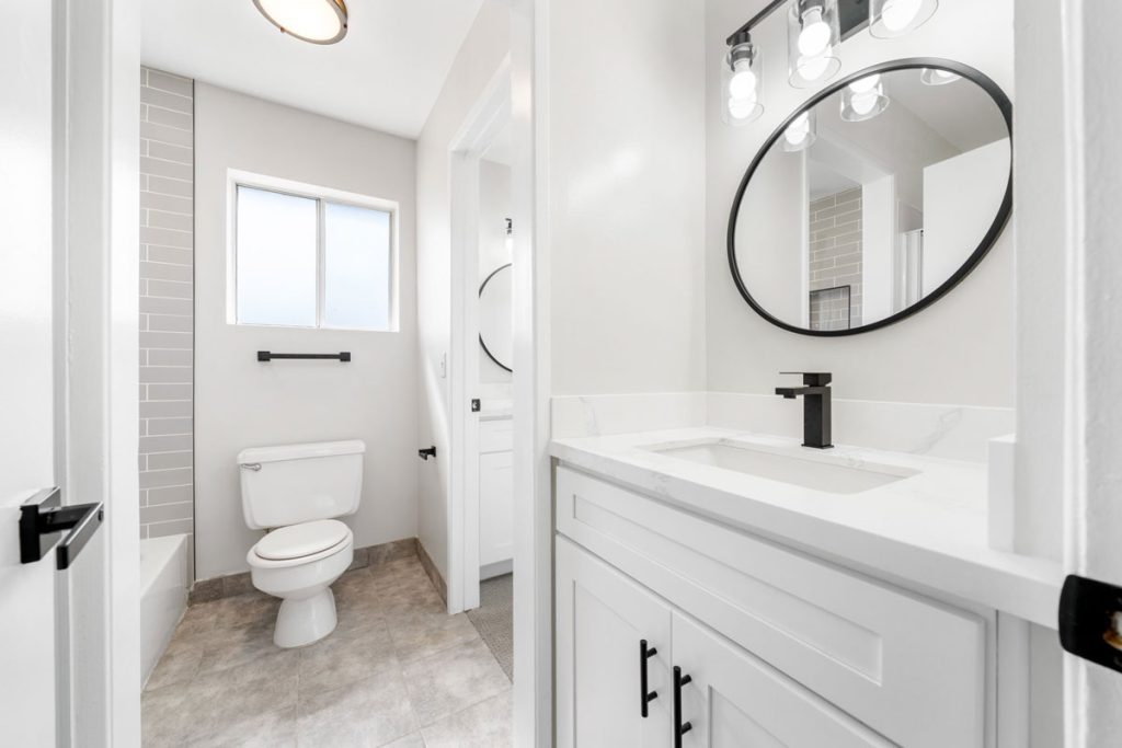 toilet and white vanity with black fixtures