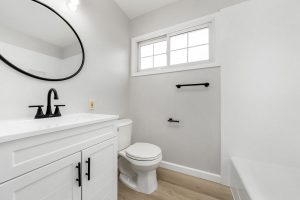 updated bathroom with white vanity and black hardware
