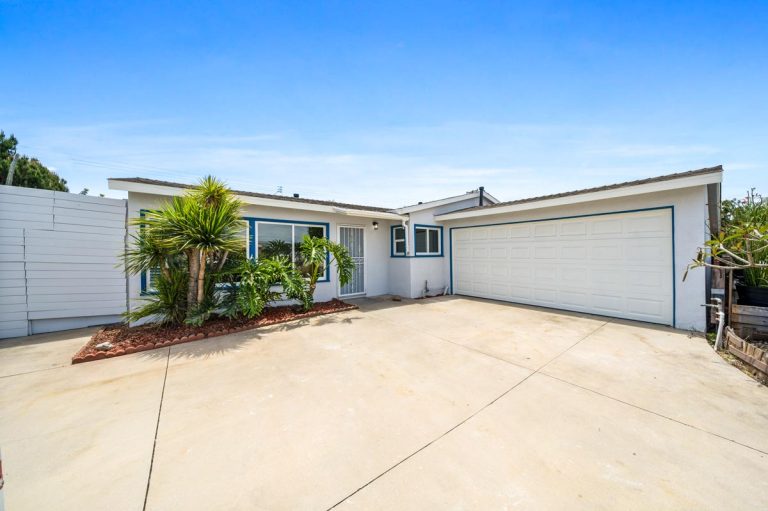 front entry showing driveway, two car attached garage and windows
