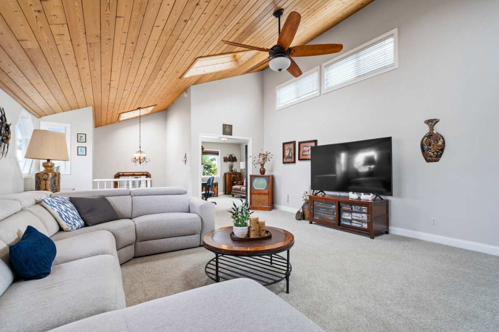 living room with vaulted, wood planked ceilings