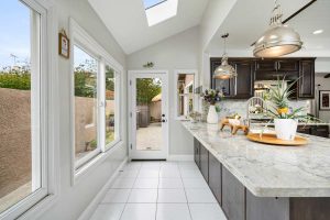 large kitchen peninsula with large windows and a door leading to the backyard