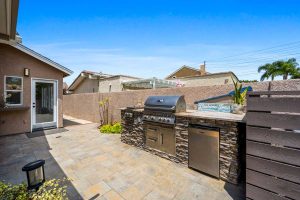 backyard kitchen with grill and fridge