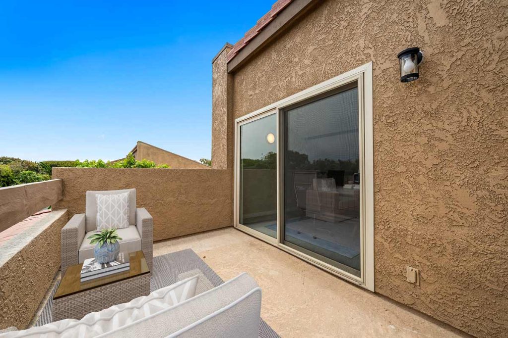 balcony with chairs and table and sliding glass door leading back inside