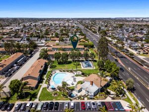 aerial view of condo for sale within a community showing pool and arrow pointing to home