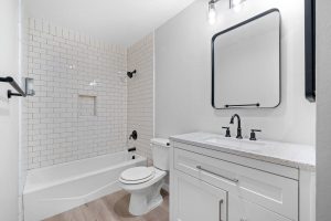 updated bathroom with white vanity, white tiles and black fixtures