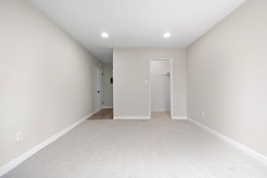 bright and empty master bedroom showing open space and closet in background