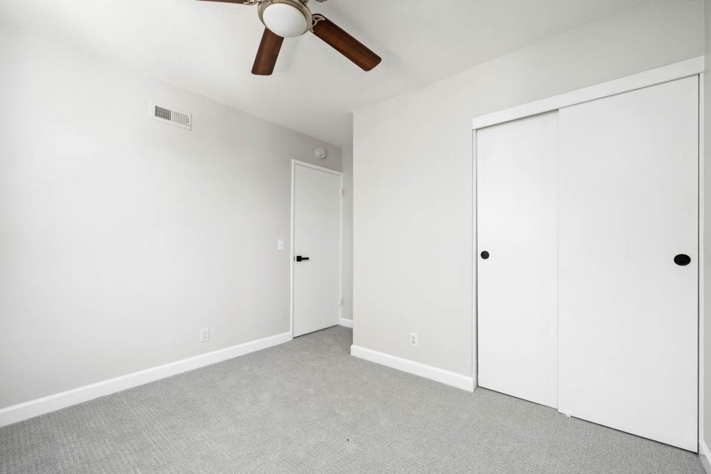 empty bedroom with closet sliding doors and ceiling fan