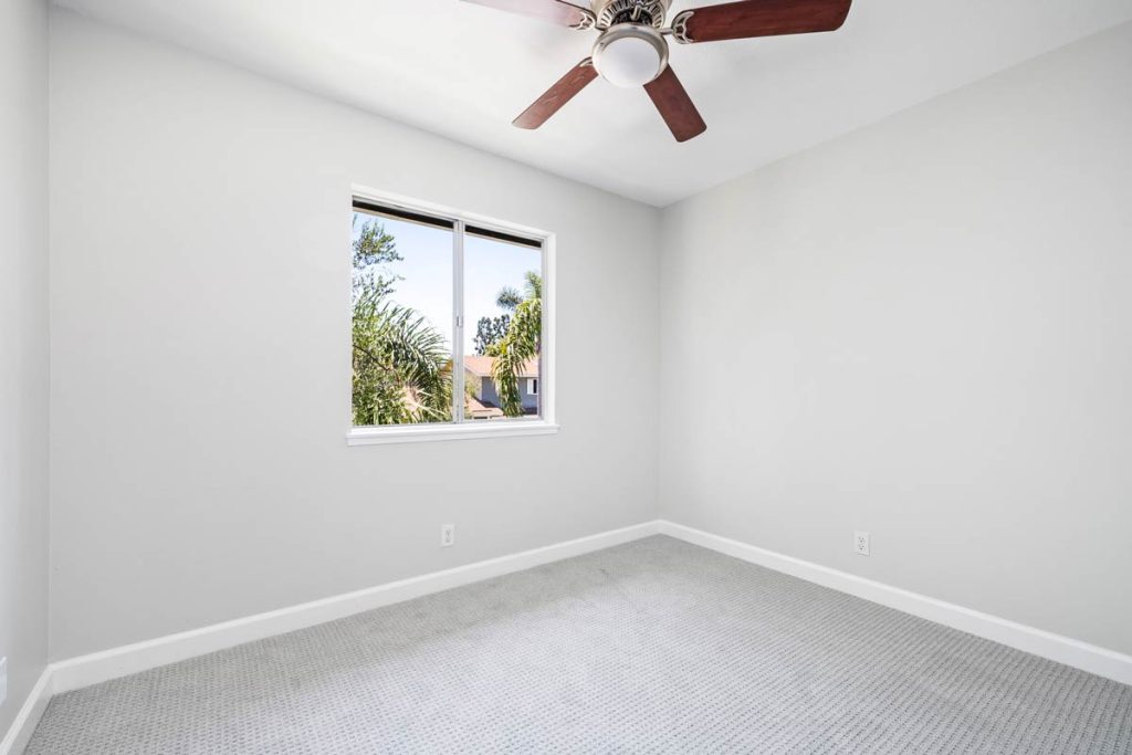 empty bedroom with ceiling fan and window