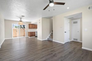 empty first floor with laminate flooring, cream colored walls and glass sliding doors leading to patio