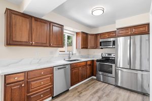 kitchen with wood cabinets, stone counter tops and stainless appliances