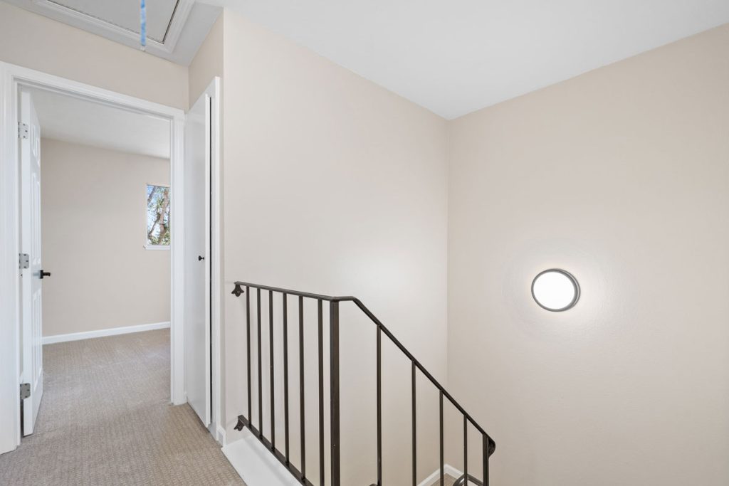 upstairs landing showing carpeted hall and bedroom entrance